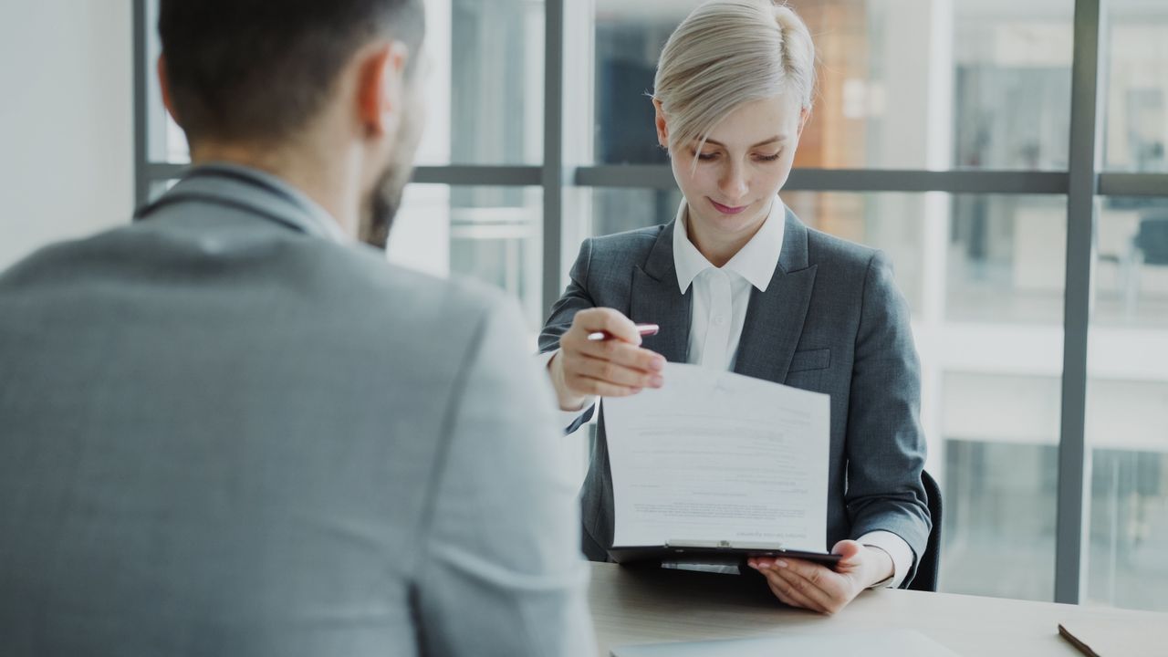 stats-img Business professionals reviewing a contract in a modern office setting.