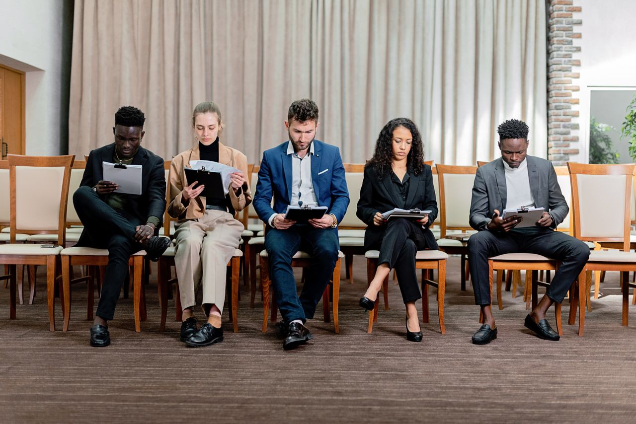 portfolio-05 A diverse group of professionals attentively reviewing documents indoors.